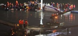 Lực lượng cứu hộ vây quanh máy bay trên sông khi trời tối dần.