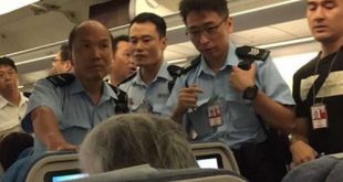 Cảnh sát lên máy bay khi nó vừa hạ cánh xuống sân bay Hong Kong.