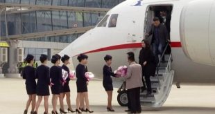 Các tiếp viên hàng không của hãng Hàng không Triều Tiên Air Koryo tặng hoa chào đón hành khách bay từ Dandong, Trung Quốc, tới Bình Nhưỡng